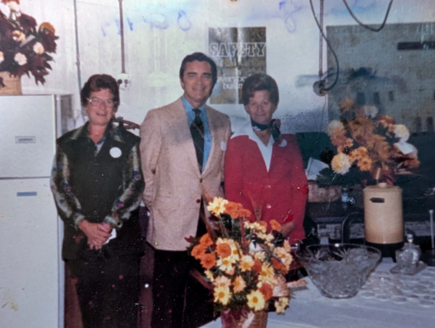 Three people gathered inside the company workplace in an archival photograph